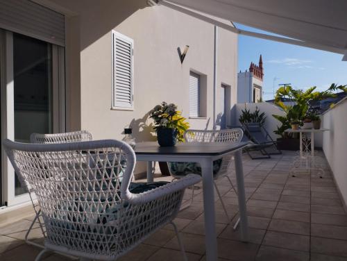 a patio with a table and chairs on a balcony at Ático con terraza La Venencia in Sanlúcar de Barrameda