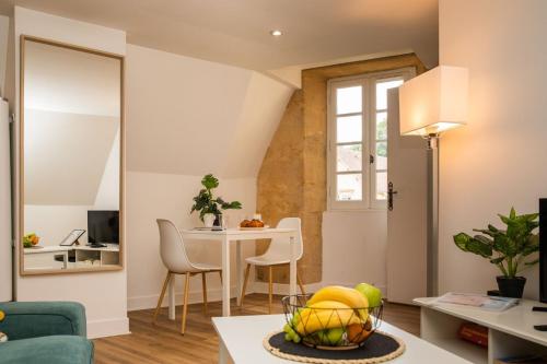 un salon avec une table et des chaises et une salle à manger dans l'établissement L'intimiste - Place de La Liberté, à Sarlat-la-Canéda