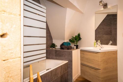 une salle de bain avec une baignoire et un lavabo dans l'établissement L'intimiste - Place de La Liberté, à Sarlat-la-Canéda