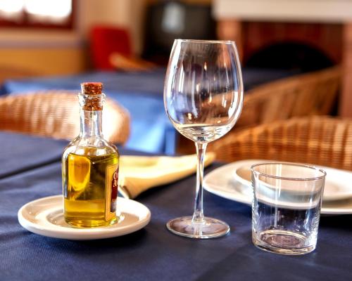 a bottle of wine and two glasses on a table at Hotel Rural El Molino de Felipe in Mula