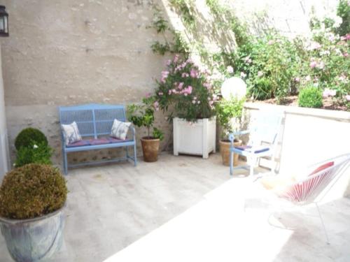 a patio with a blue bench and some plants at Les Pensées - Chambre Turner in Orléans