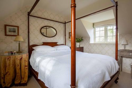 a bedroom with a large bed with a wooden frame at Wychwood Cottage in Bruern