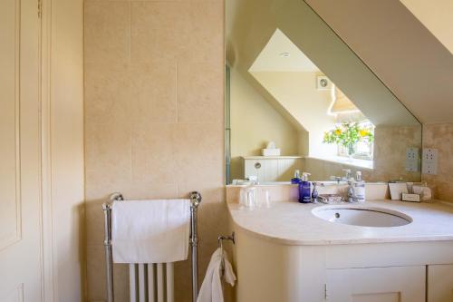 a bathroom with a sink and a mirror at Wychwood Cottage in Bruern