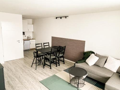 Harzträume Panorama Lodge, im Harz, mit Schwimmbad und Sauna في برونلاغ: غرفة معيشة بها طاولة وأريكة