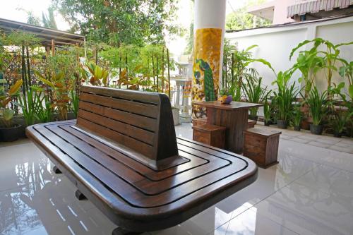 a wooden bench sitting on a patio with plants at Jade Tower in Chiang Mai