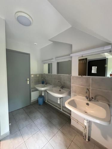 a bathroom with two sinks and two mirrors at Gite de la Croix du Hêtre in Hambers