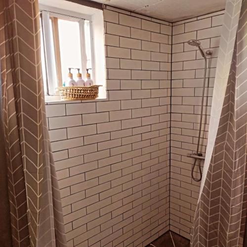 a white tiled shower with a window in a bathroom at Hilltop Cabin in Black Bay Laborie in Laborie