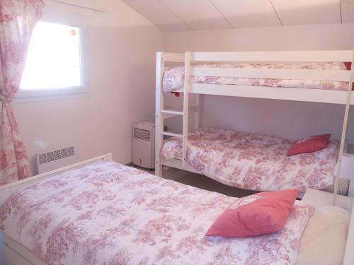 une chambre avec deux lits superposés et une fenêtre dans l'établissement VILLA 3 PIECES 51m2 + TERRASSE 45m2 REF 4033, à Le Castellas