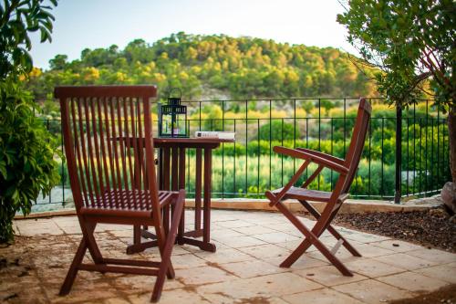 two chairs and a table with a view of a fence at Hotel Rural El Molino de Felipe in Mula