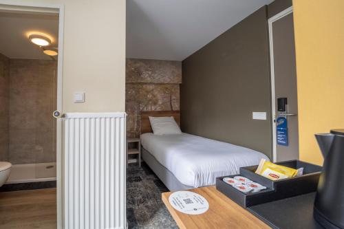 a bedroom with a bed and a bathroom with a tub at Fletcher Hotel Restaurant Erica in Berg en Dal