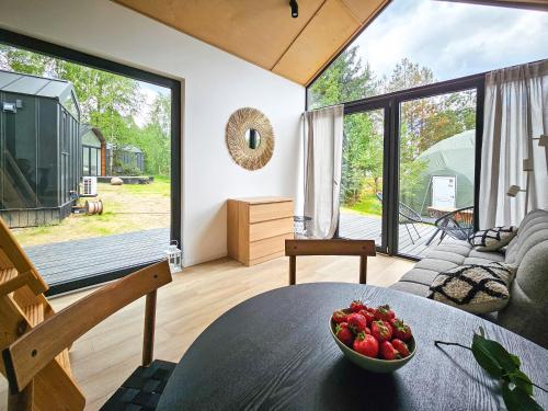 SkorzewoにあるKaszuby Tree Houseのフルーツのボウルが置かれたテーブルのあるリビングルーム