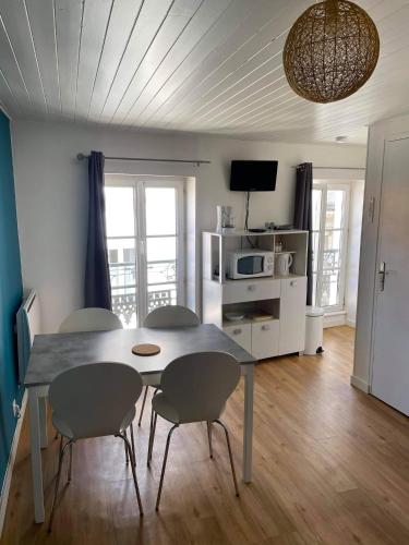 une table à manger et des chaises dans un salon dans l'établissement Charmant studio en hyper centre, à Les Sables-dʼOlonne
