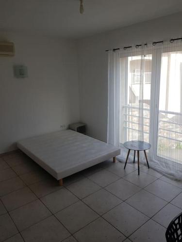 a white room with a bed and a table at Loue studio in Corte