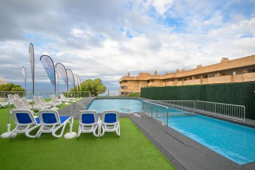 a group of chairs sitting next to a swimming pool at Albatros Family in Salou