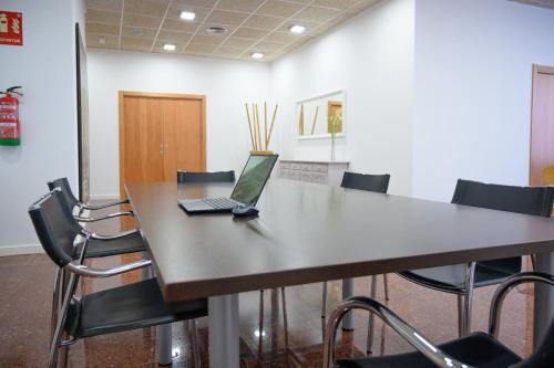 a laptop sitting on a table in a room with chairs at Albatros Family in Salou