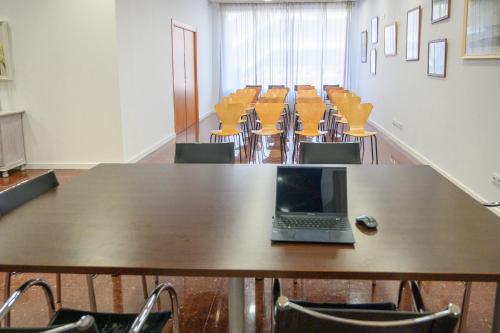 a laptop on a table in a room with chairs at Albatros Family in Salou