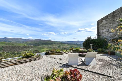 a patio with two benches and a view of the mountains at Casas das Olas in Arcos de Valdevez
