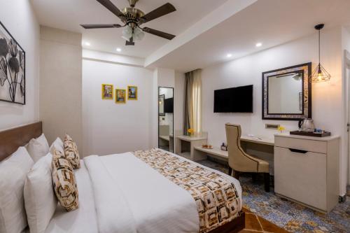 a hotel room with a bed and a desk at Sterling Marbella Dehradun in Dehradun