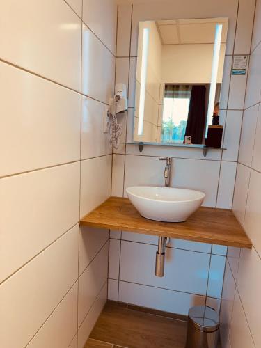 a bathroom with a sink and a mirror at Enns Sleep Gasthaus Backhendlstation in Enns