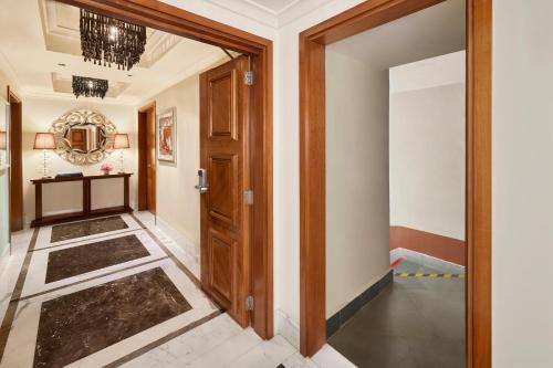 a hallway with a wooden door and a tile floor at Taj Palace, New Delhi in New Delhi