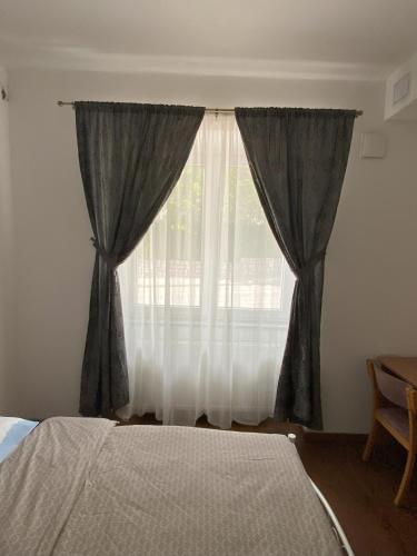 a bedroom with a bed and a window with curtains at Lavender in Postojna