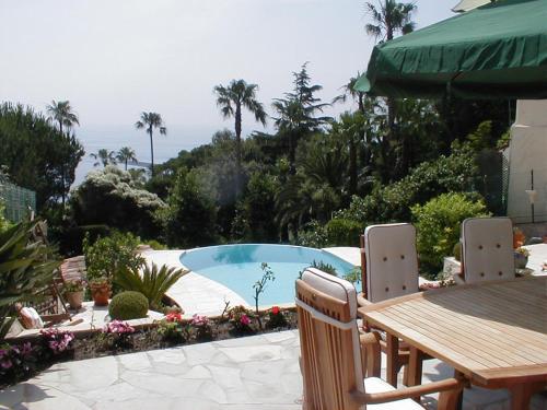 - une table et des chaises à côté de la piscine dans l'établissement Maison Louijane, à Vallauris