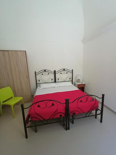 a bedroom with a bed and a green chair at TETIDE Holiday home,casa vacanze in Trapani
