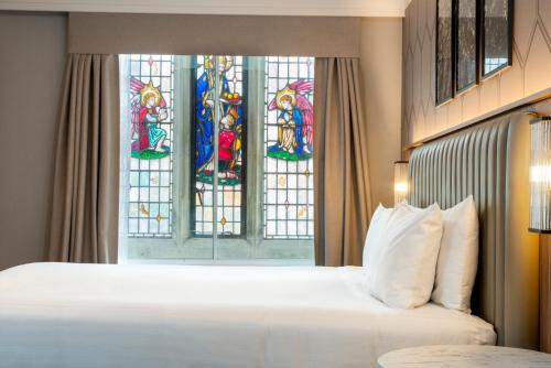 a bedroom with a bed and a stained glass window at London Chigwell Prince Regent Hotel, BW Signature Collection in London