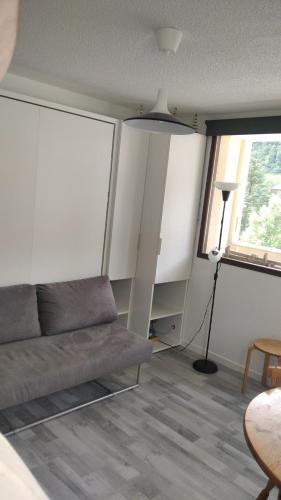 un salon avec un canapé et une fenêtre dans l'établissement Le Petit Som de Saint Pierre de Chartreuse, à Saint-Pierre-de-Chartreuse
