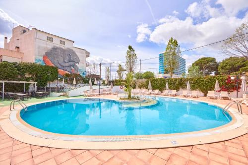a large swimming pool with chairs and a building at Ilusion Markus & Spa in Can Picafort