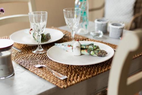 a table with two plates and wine glasses on it at Le petit chapitre in Fosses-La-Ville