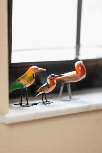 three small birds sitting on a window sill at Le petit chapitre in Fosses-La-Ville