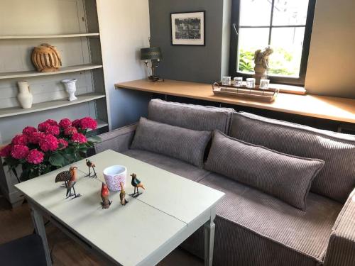 a living room with a couch and a table with figurines on it at Le petit chapitre in Fosses-La-Ville