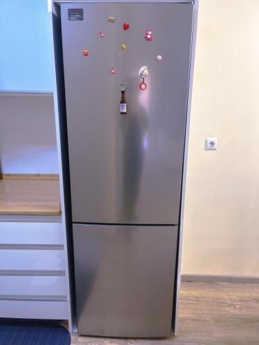 a stainless steel refrigerator with magnets on it at 甜水之家 in Glyka Nera