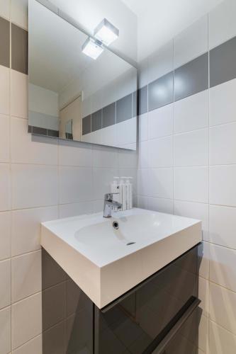 une salle de bain avec un lavabo blanc et un miroir dans l'établissement 204 - Charmant studio jardins des plantes -Paris 5 - FLAT-GUEST, à Paris
