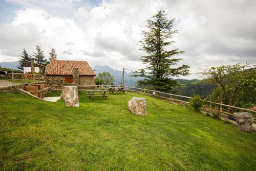 a park with a picnic table and two rocks in the grass at Apartamentos Cal Rum in Campelles