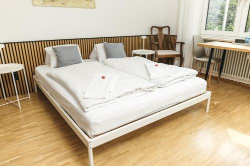a white bed in a room with tables and chairs at HEIMATEL - Ferienhaus Blümele in Scheidegg