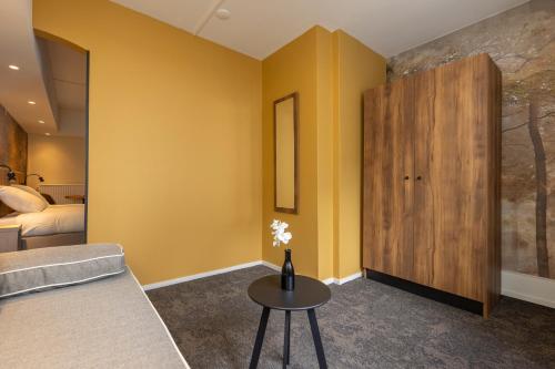 a living room with yellow walls and a table at Fletcher Hotel Restaurant Erica in Berg en Dal