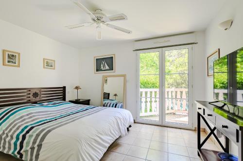une chambre blanche avec un lit et un balcon dans l'établissement Villa familiale avec piscine dans la pinède à 4min de l'océan-AG13, à Lacanau