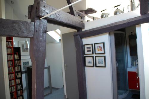 une pièce avec deux poutres en bois et une porte dans l'établissement Combles et volutes, à La Roche-Posay