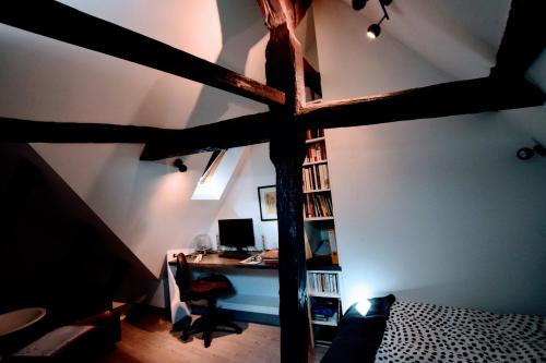 une chambre avec un lit mezzanine avec un bureau et un ordinateur dans l'établissement Combles et volutes, à La Roche-Posay