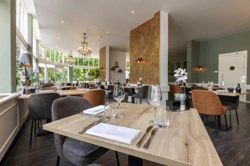 a dining room with wooden tables and chairs at Fletcher Hotel Restaurant Erica in Berg en Dal