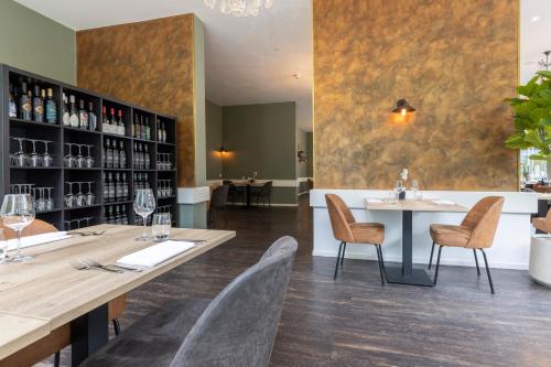 a restaurant with a table and chairs and a bar at Fletcher Hotel Restaurant Erica in Berg en Dal