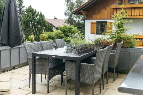 a black table and chairs on a patio at HEIMATEL - Ferienhaus Blümele in Scheidegg