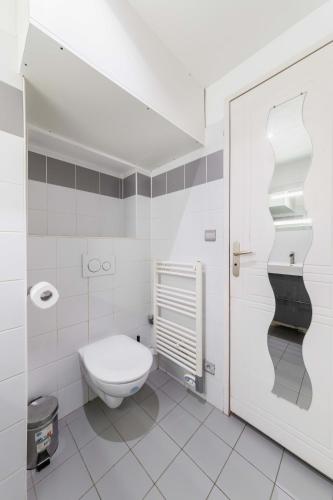 La salle de bains blanche est pourvue de toilettes. dans l'établissement 505- Charmant studio jardins des plantes -Paris 5 - FLAT-GUEST, à Paris