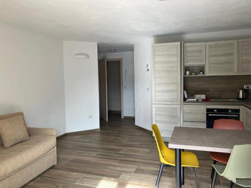 a living room and kitchen with a couch and a table at Maison Doél in Ragoli