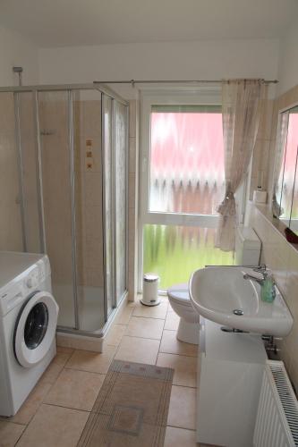 a bathroom with a sink and a washing machine at Jantje in Norddeich
