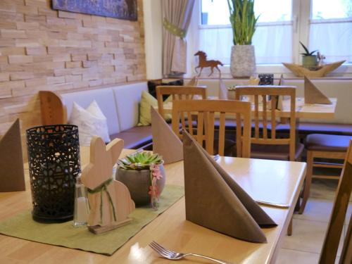 a dining room with tables and chairs and a table with a fork at Landgasthof zum Rappen in Creglingen