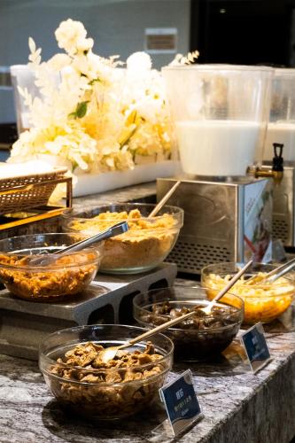 a buffet with bowls of food on a table at Talmud Hotel Kaohsiung LoveRiver in Kaohsiung