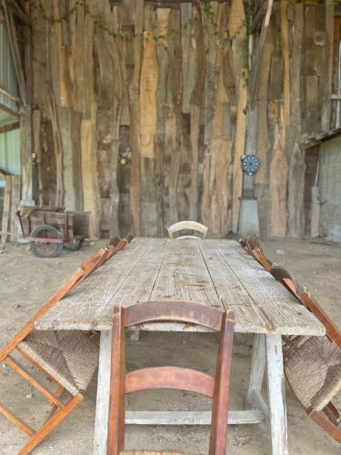 an old wooden table with two chairs around it at Villa Nid d'Oiseaux in Lustar